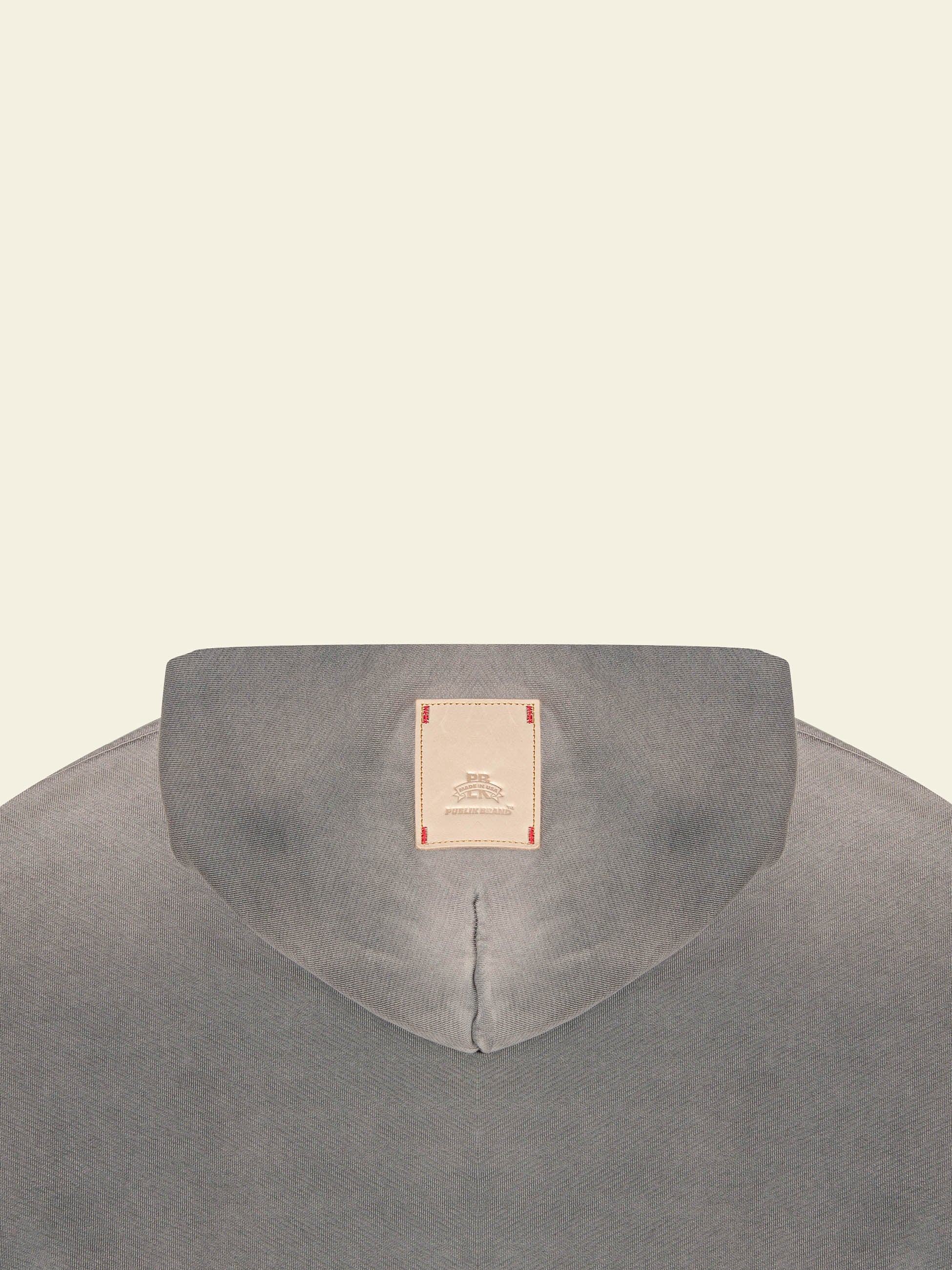 detail of the brand logo leather patch on the double layered hood