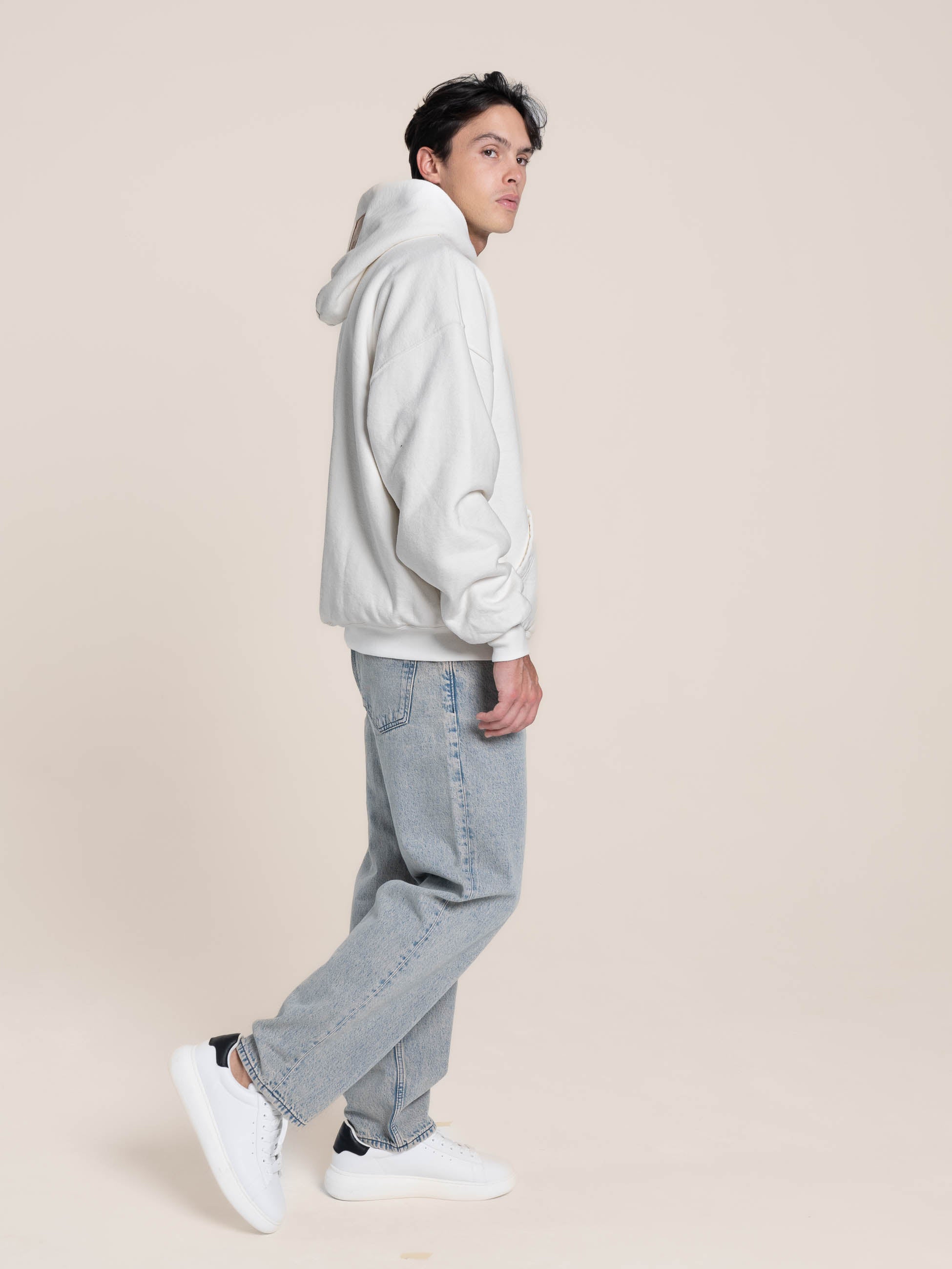 Male Model wears Publik Brand Double Layered Hoodie Acoustic White Heavyweight Fleece, all made in USA, side view