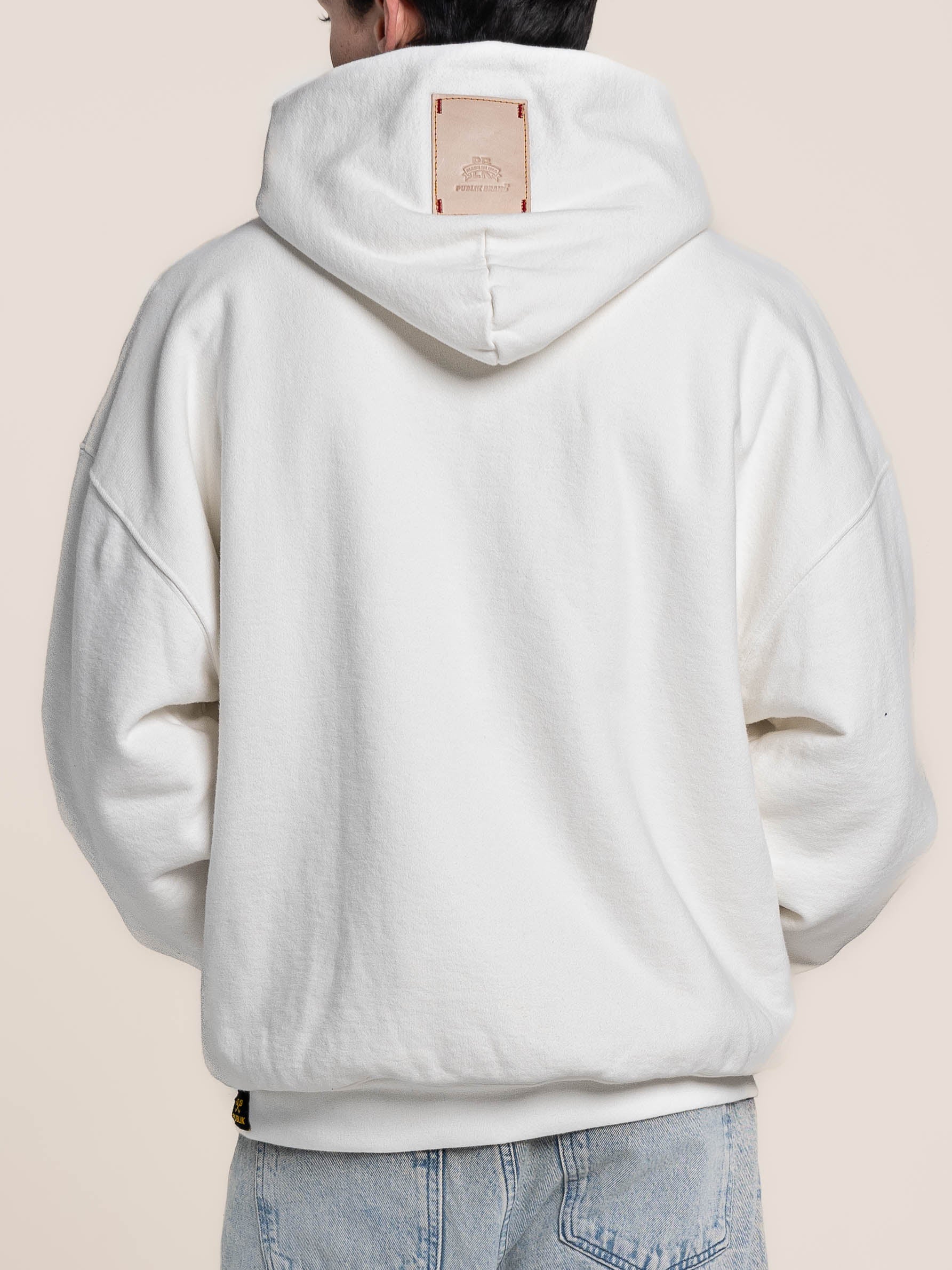 Male Model wears Publik Brand Double Layered Hoodie Acoustic White Heavyweight Fleece, back side,  all made in USA