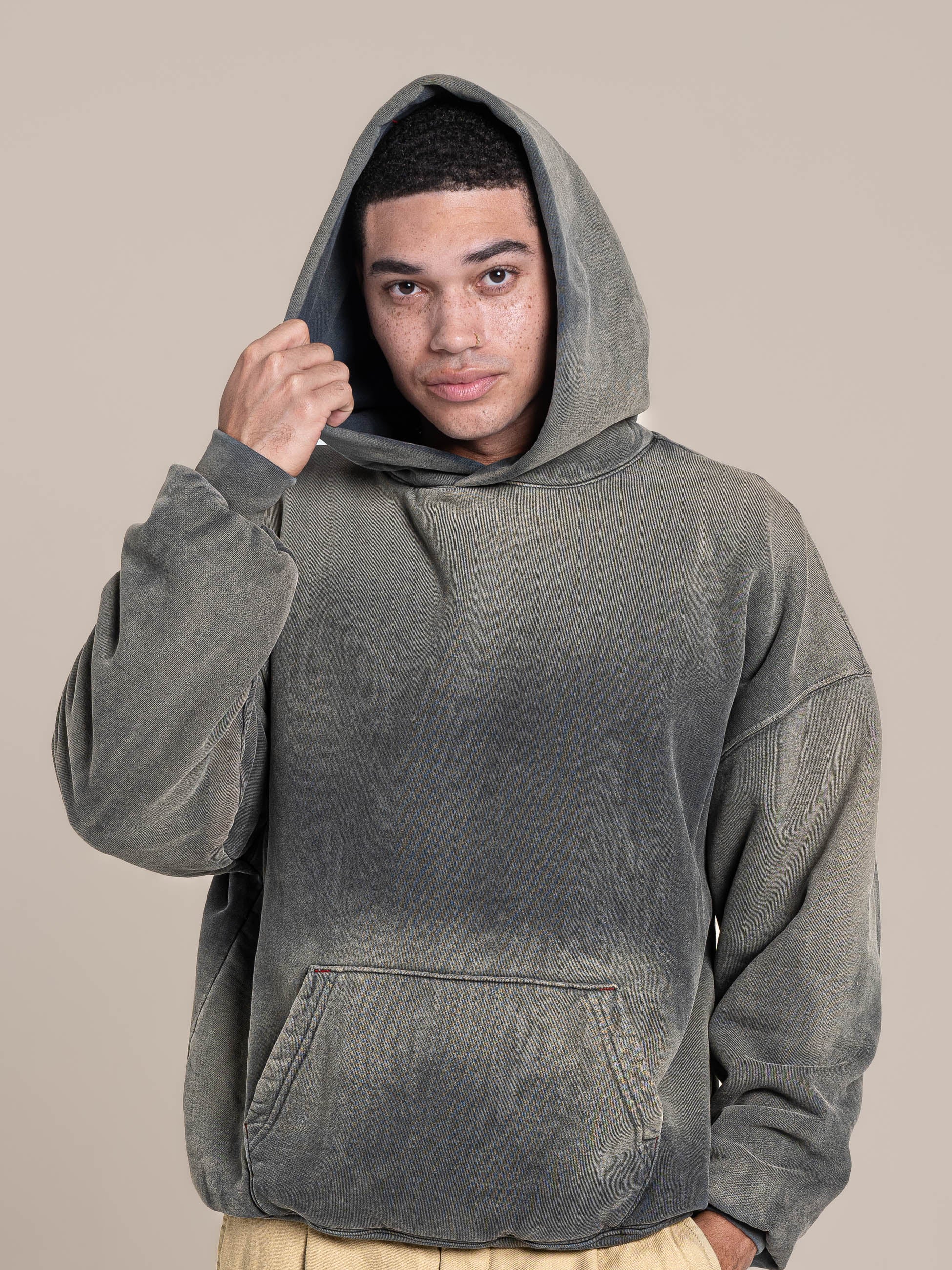 Male Model holds a hood of Publik Brand Double Layered Grey Hoodie Luxury Made in USA
