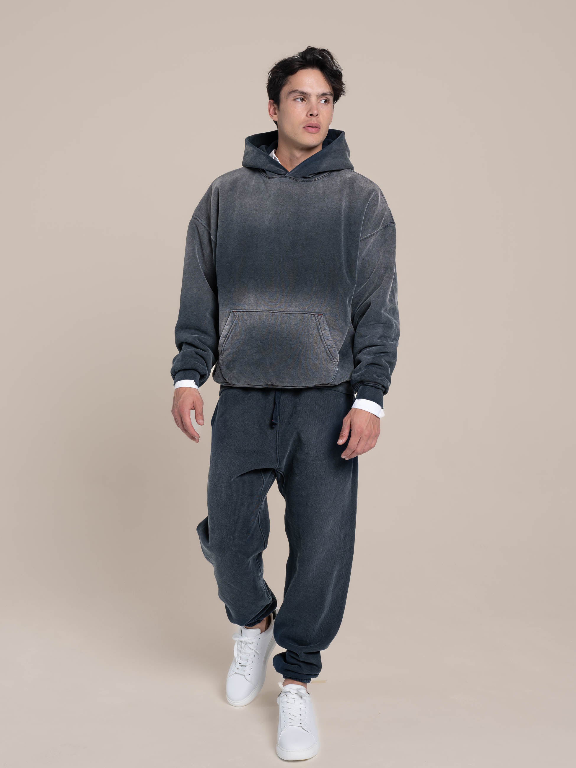 Male Model is walking with Navy Hoodie and Navy Sweatpants Made in USA