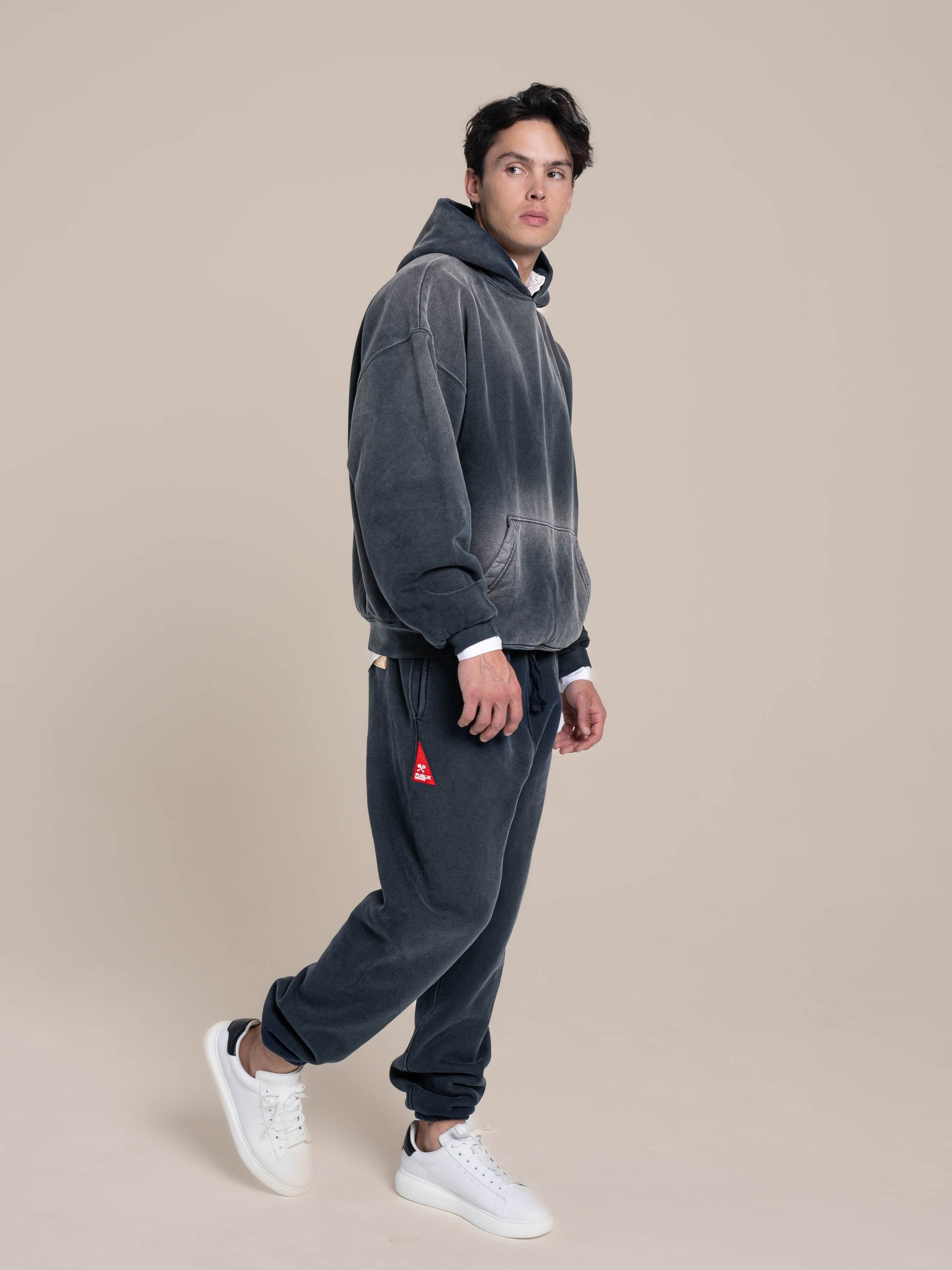 Male Model wears a Publik Brand Double Layered Fleece Navy Hoodie with Relaxed Fleece Navy Sweatpants Made in USA