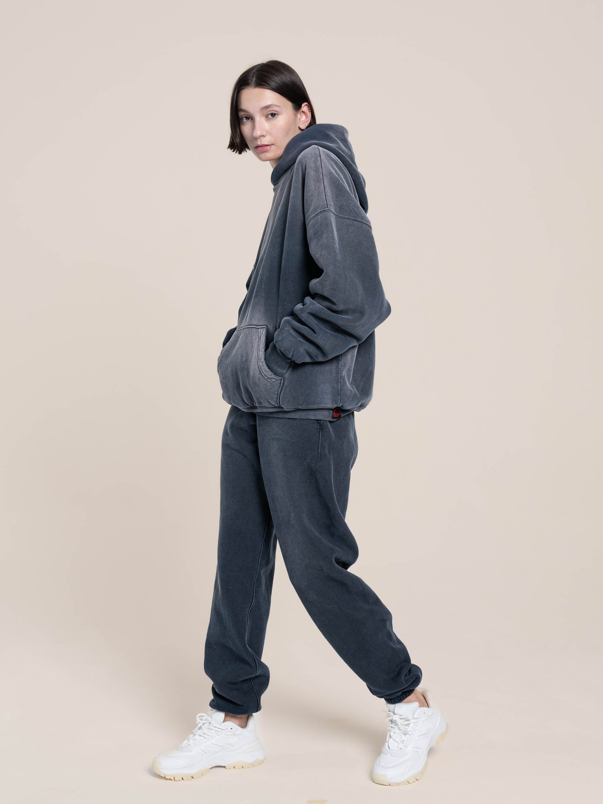Female Model wears the small size of the double layered fleece navy hoodie and fleece navy sweatpants Made in USA