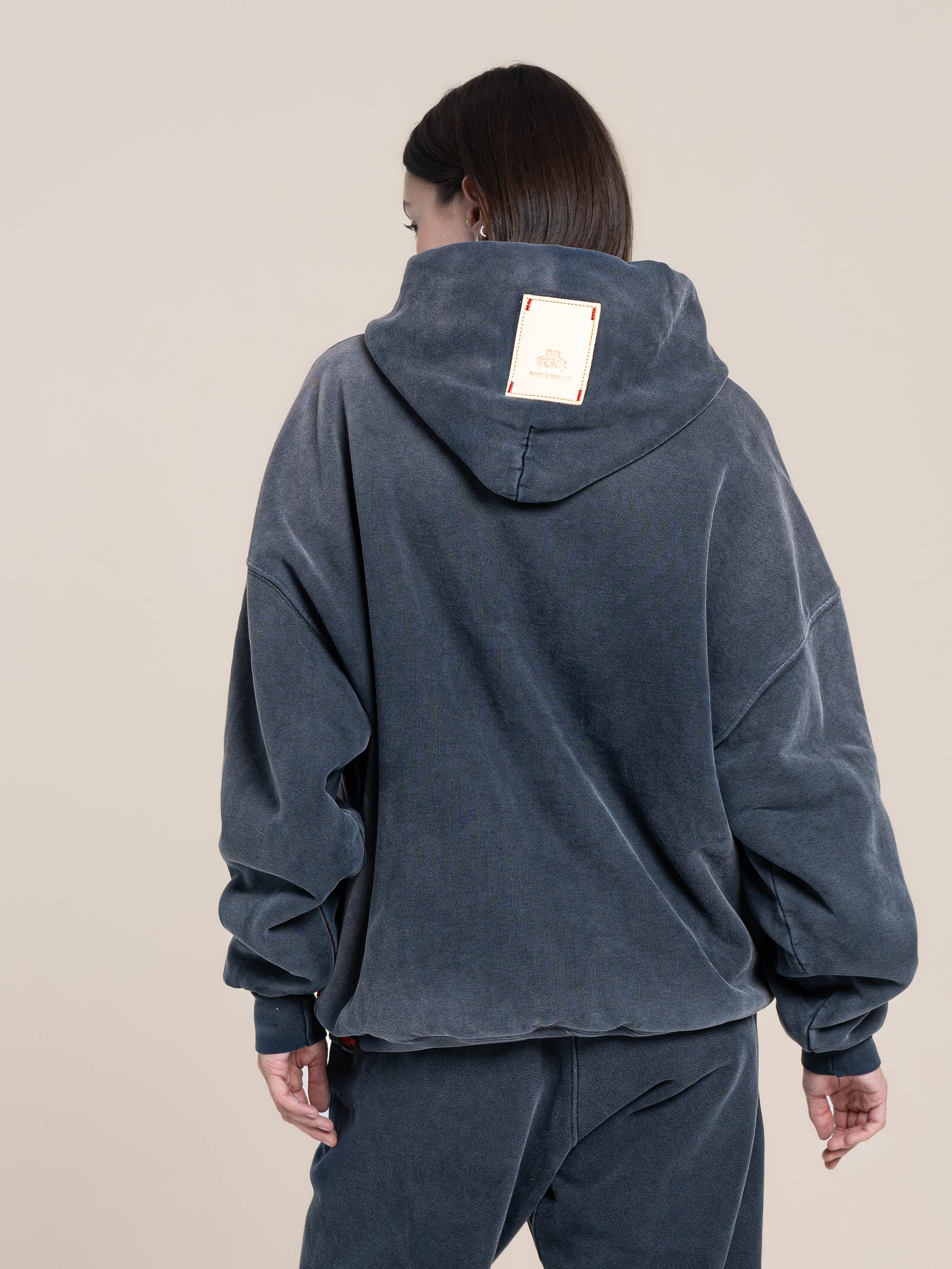 female shows back of the double layer hoodie  logo leather patch  Made in USA