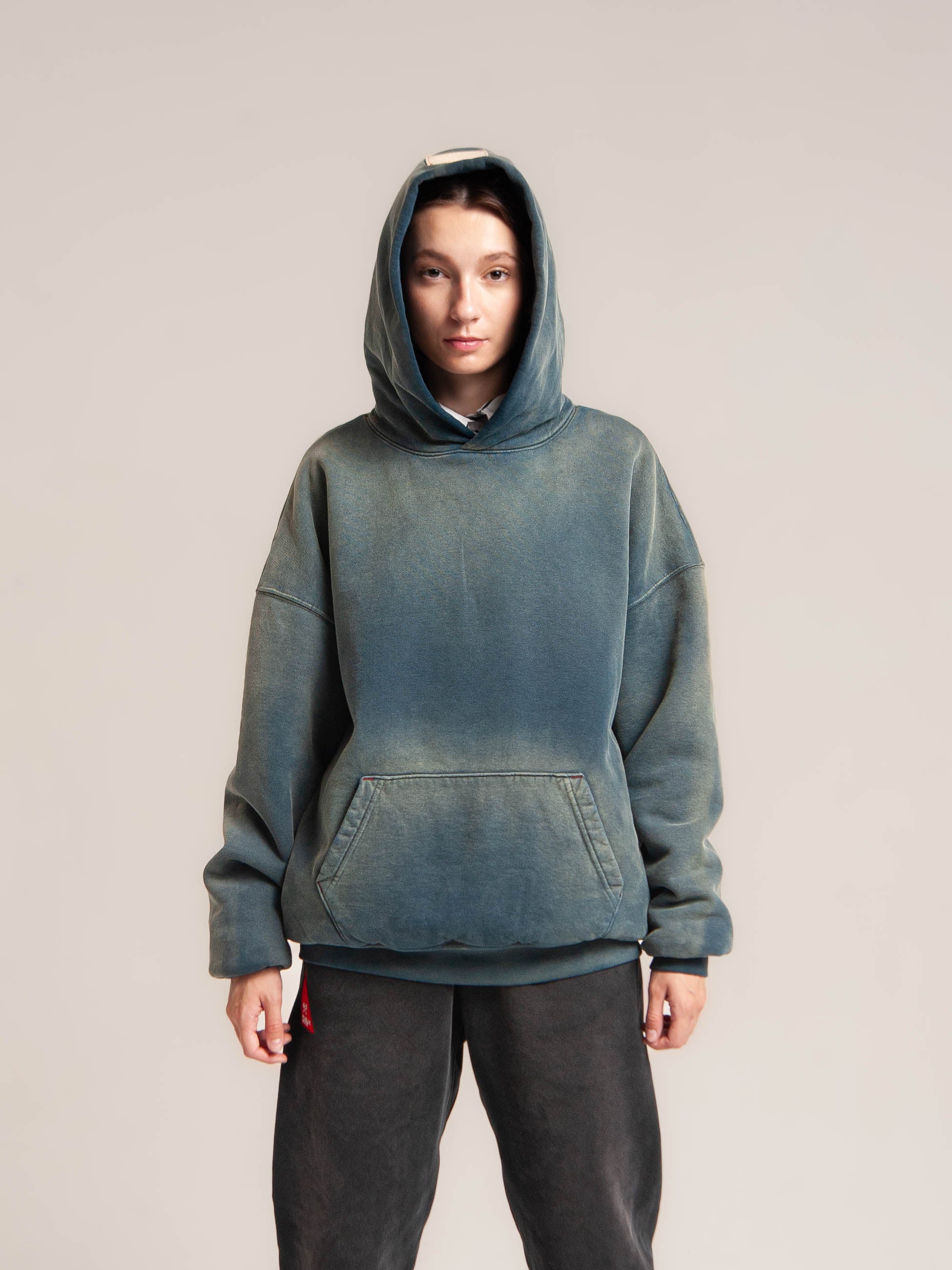 Female model pull over hood of the double layered fleece indigo hoodie