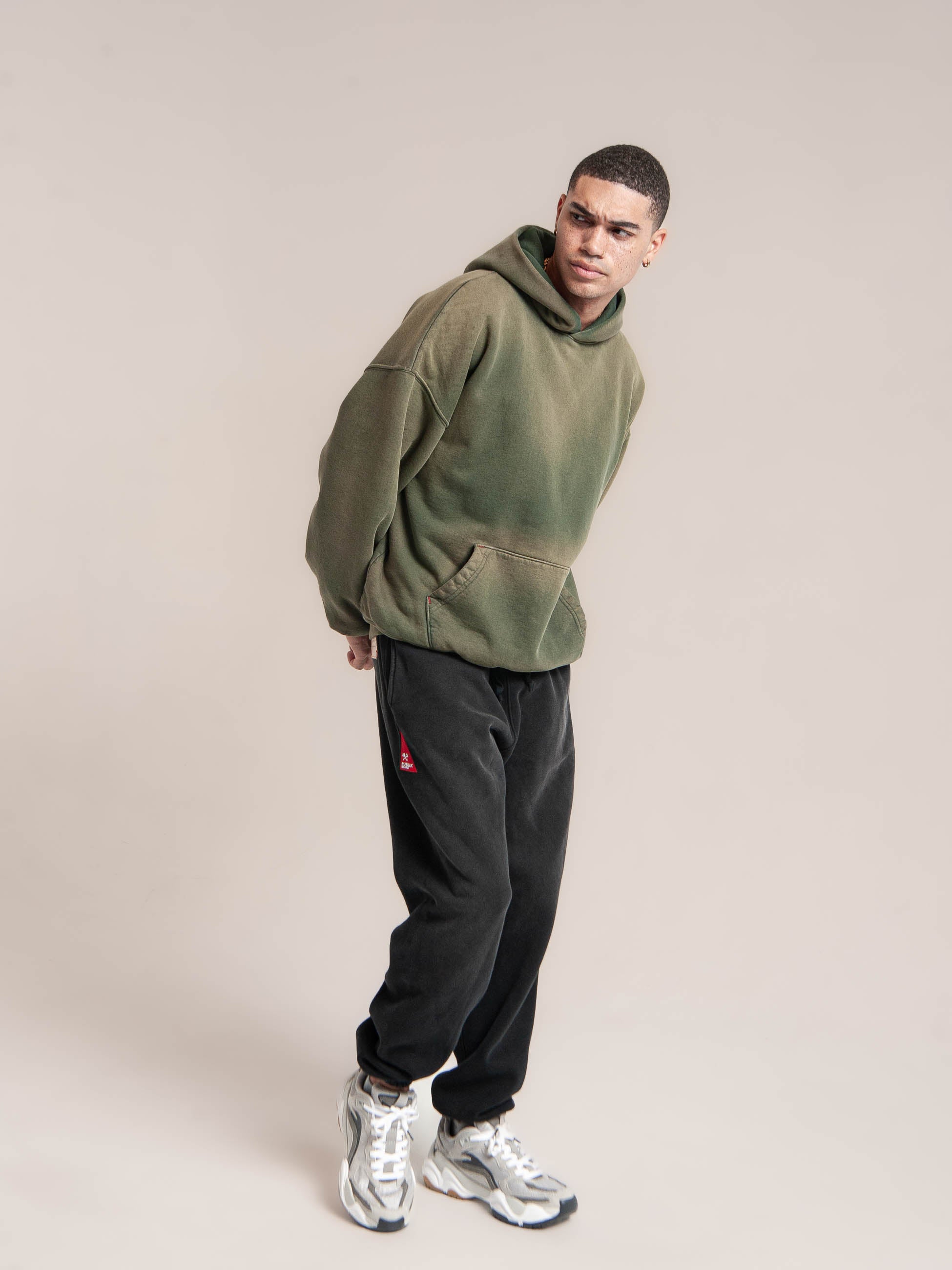 male model wears Publik Brand Double Layered Hoodie Reseda Green Heavyweight Fleece, all made in USA and looking a side.