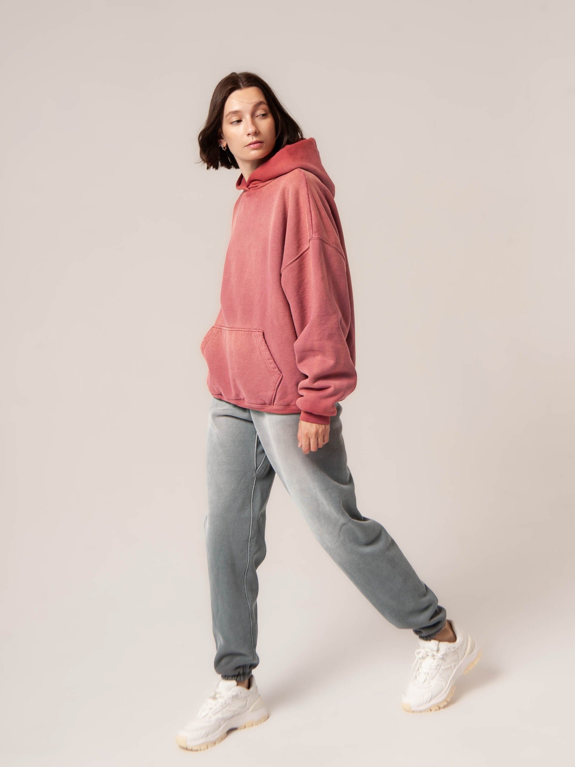 Female model wears Publik Brand Double Layered Hoodie Tea Rose Red Heavyweight Fleece, all made in USA