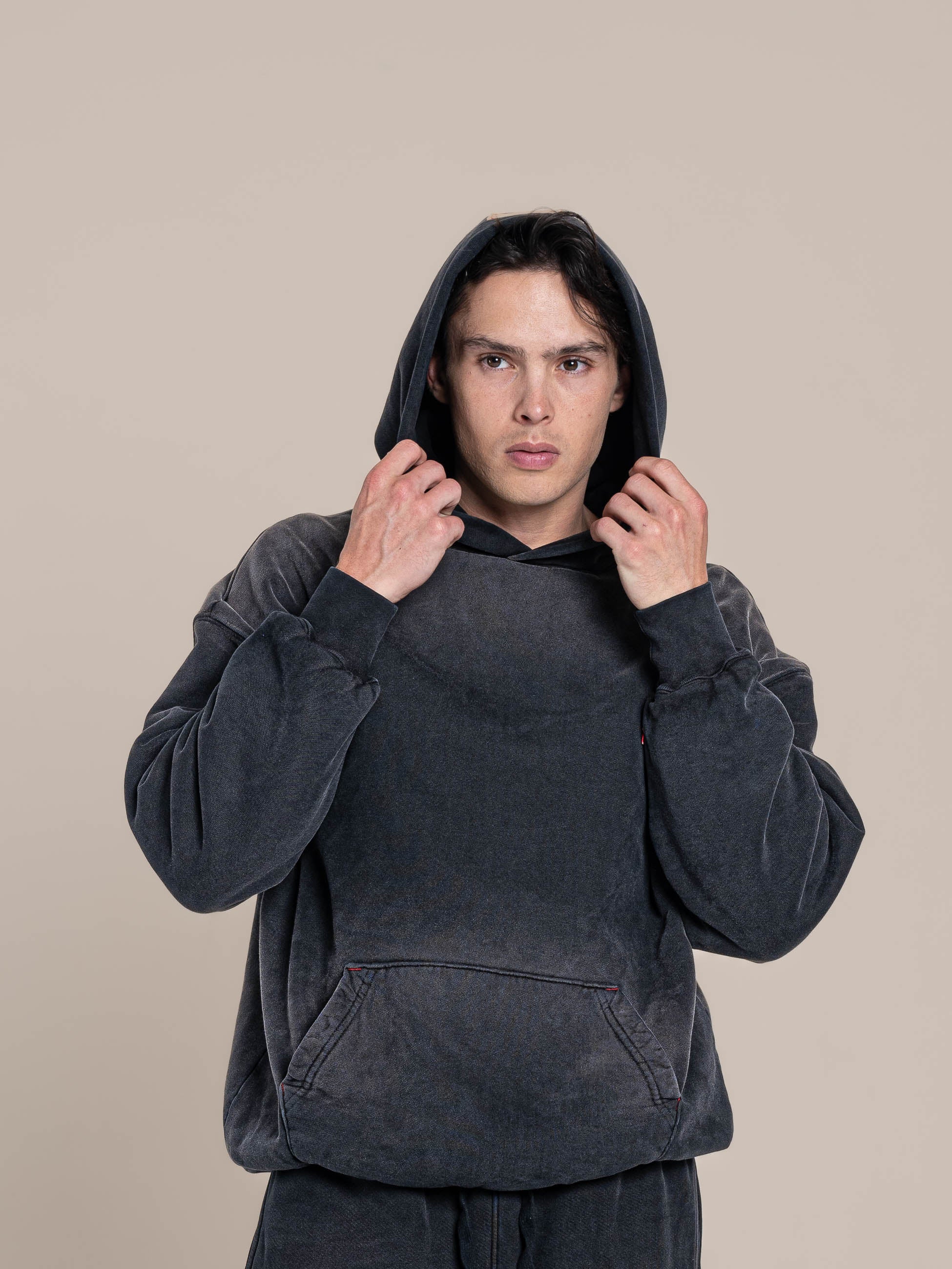 Male Model Hold Hood of the Publik Brand Double Layered Fleece Black Hoodie Double Layered Fleece Black Hoodie Flat Luxury Made in USA