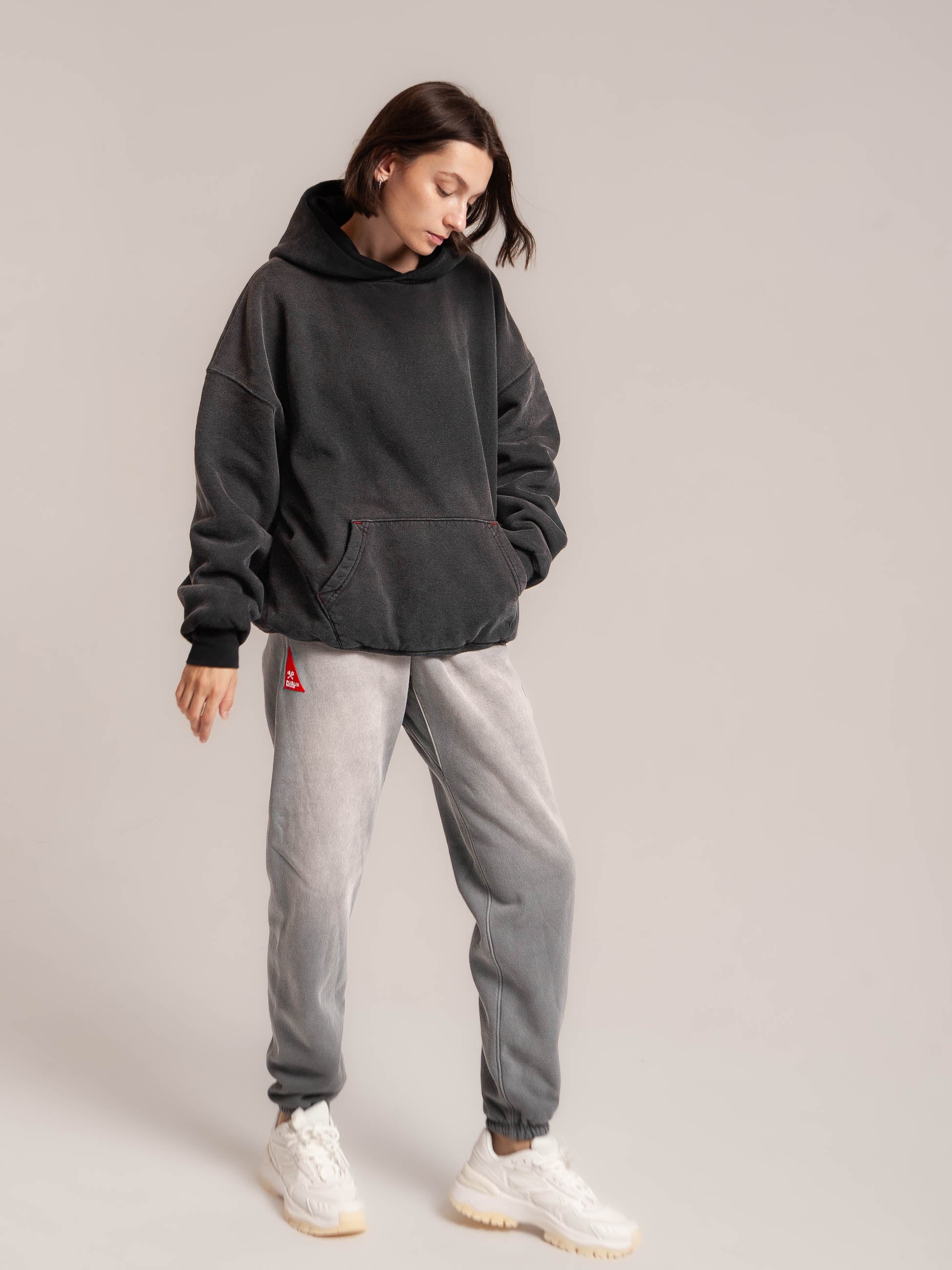 Female Model look down to see Publik Brand Fleece Ash Blue Sweatpants Double Layered Fleece Black Hoodie Flat Luxury Made in USA