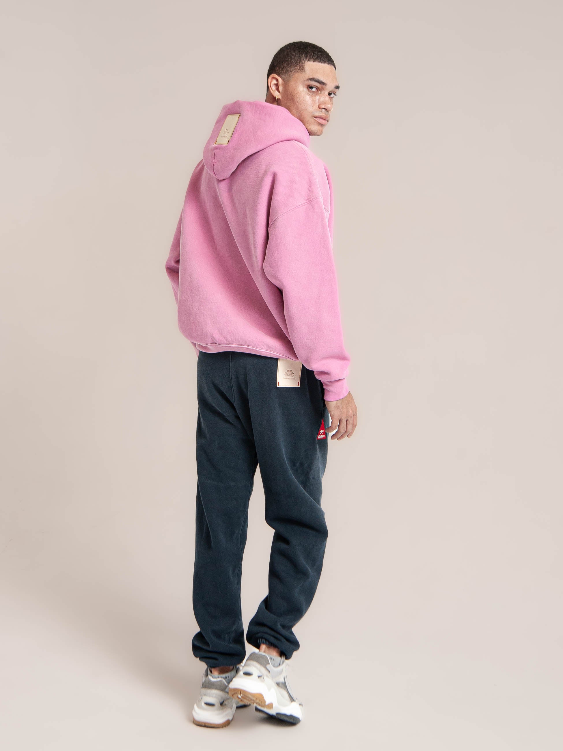 male model wears Publik Brand Single Layered Hoodie Hollywood Cerise Pink Heavyweight Fleece, all made in USA, back side