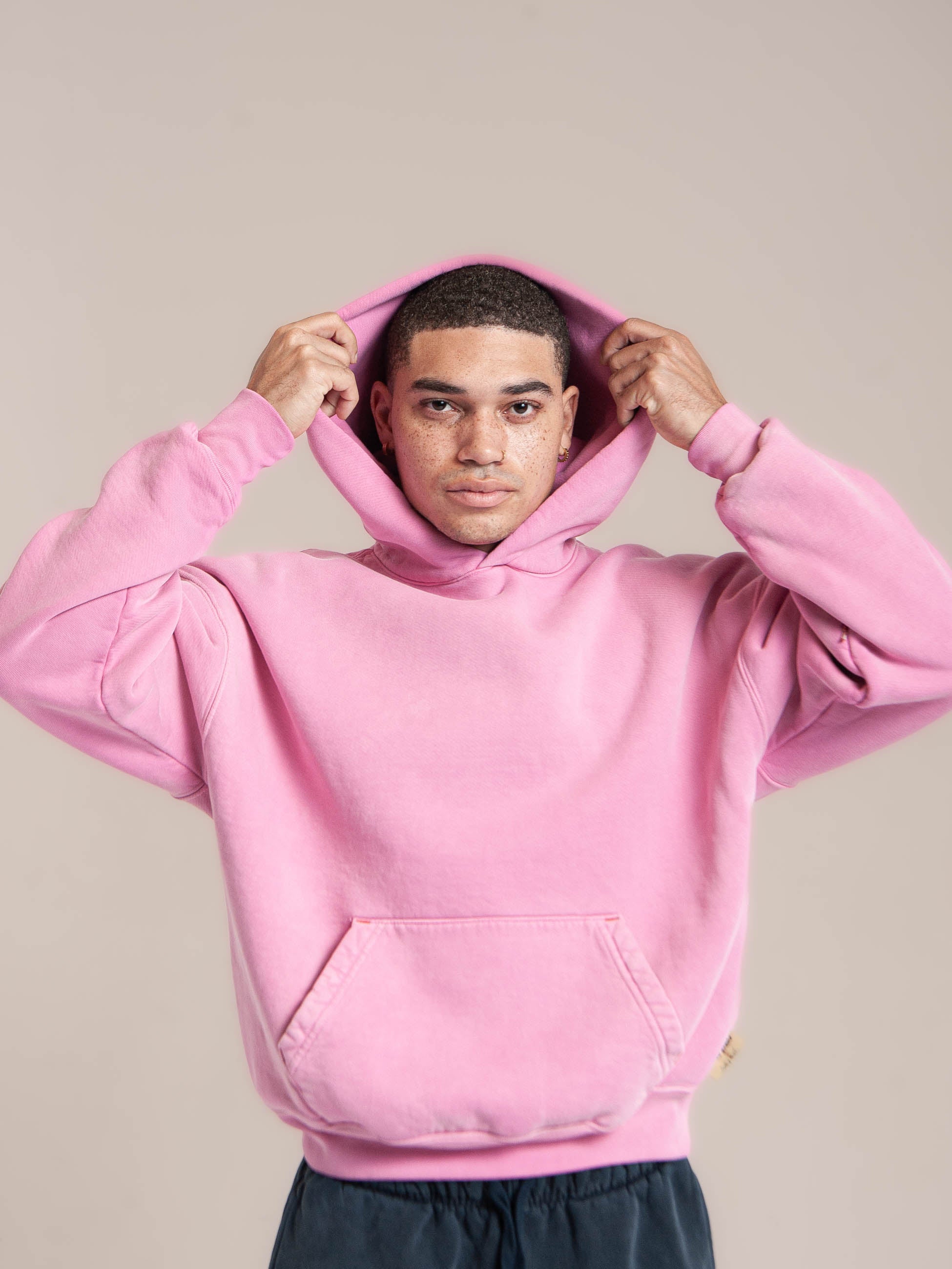 male model wears Publik Brand Single Layered Hoodie Hollywood Cerise Pink Heavyweight Fleece, all made in USA