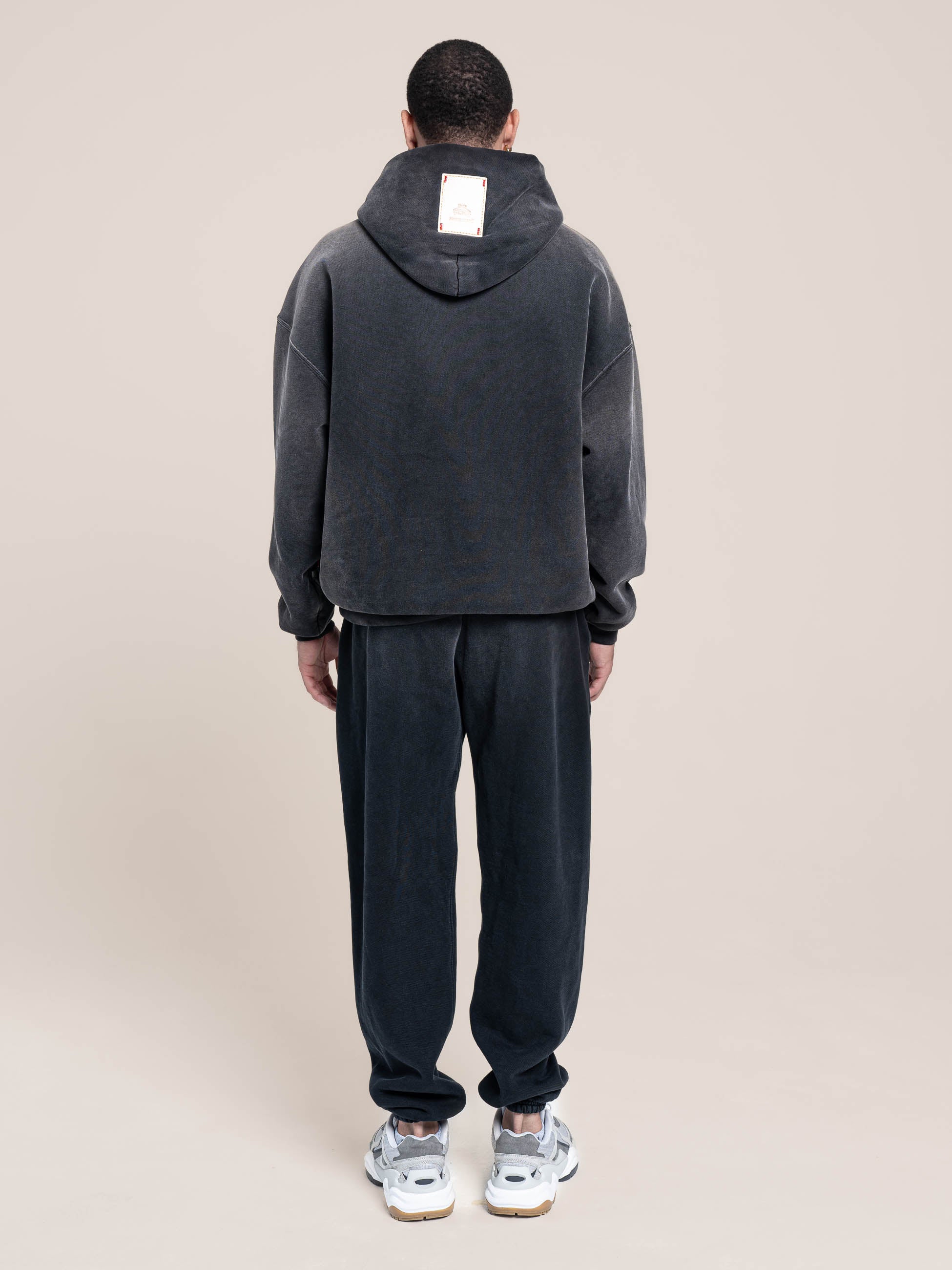 Male Model wears Publik Brand Single Layered Hoodie Yacht Club Black Heavyweight Fleece, all made in USA, back side