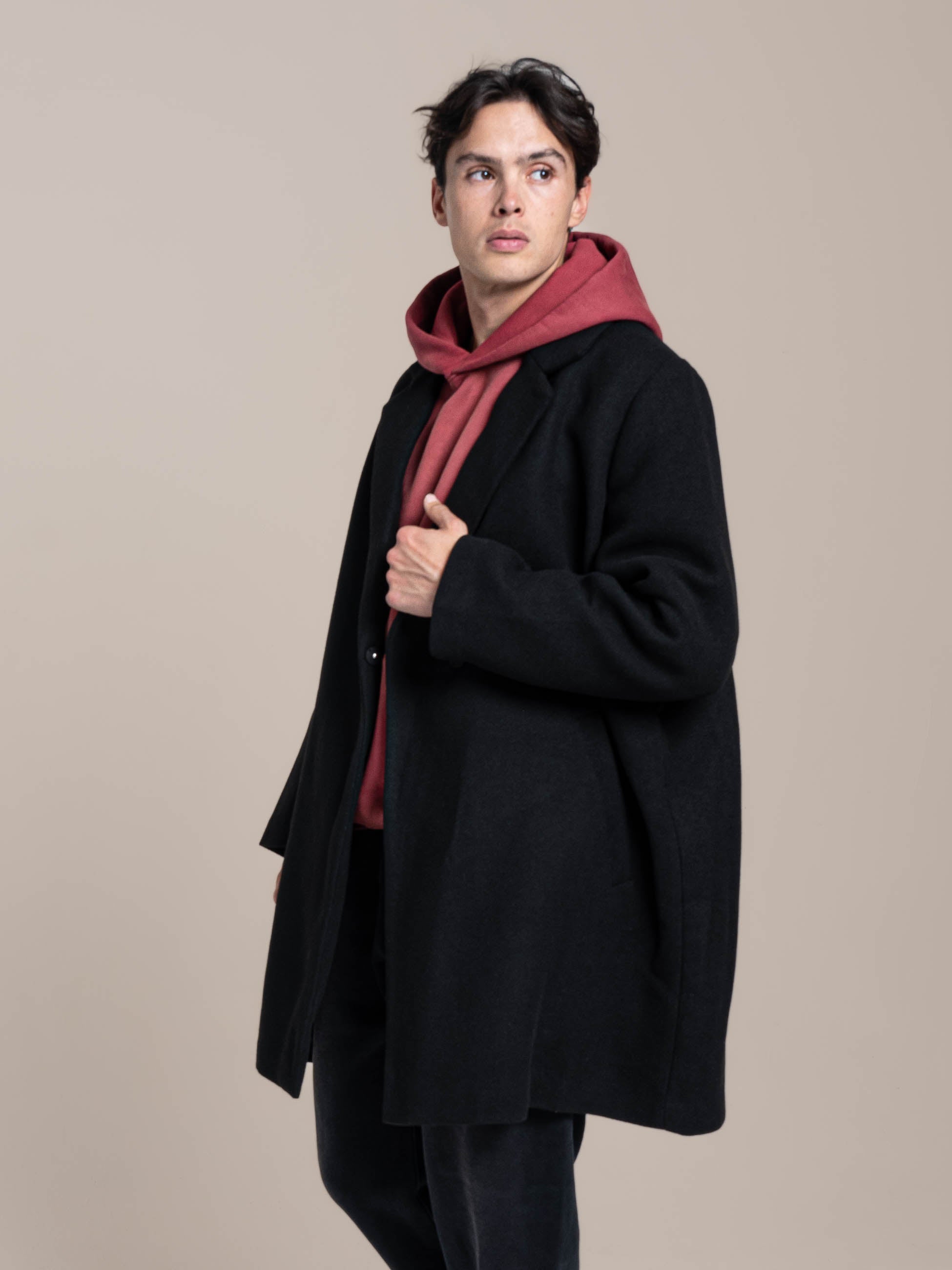 male model wears Publik Brand Double Layered Hoodie Tea Rose Red Heavyweight Fleece with wool blended coat, all made in USA