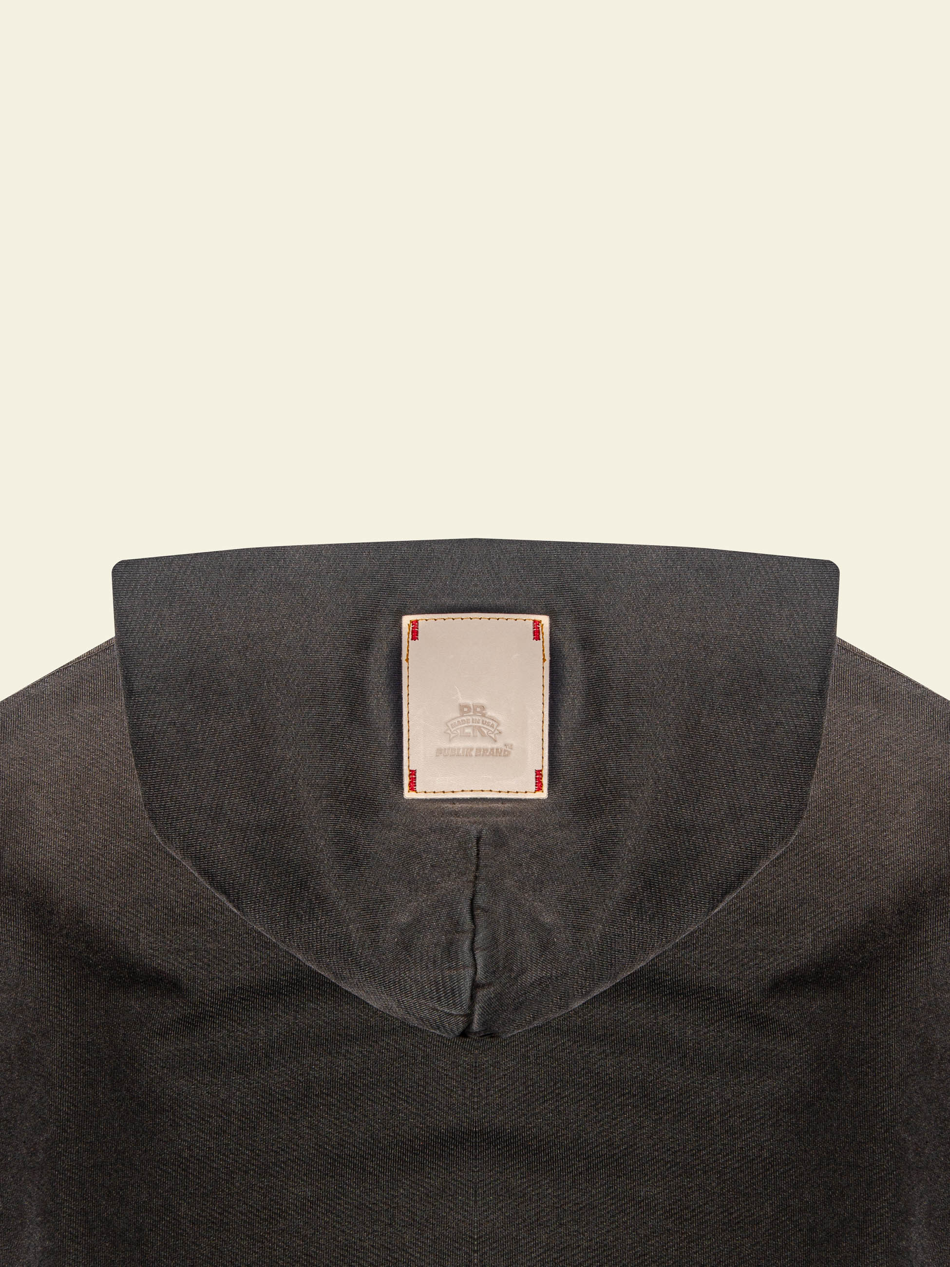 A brand logo leather patch detail of Publik Brand Double Layered Fleece Black Hoodie Double Layered Fleece Black Hoodie Flat Luxury Made in USA